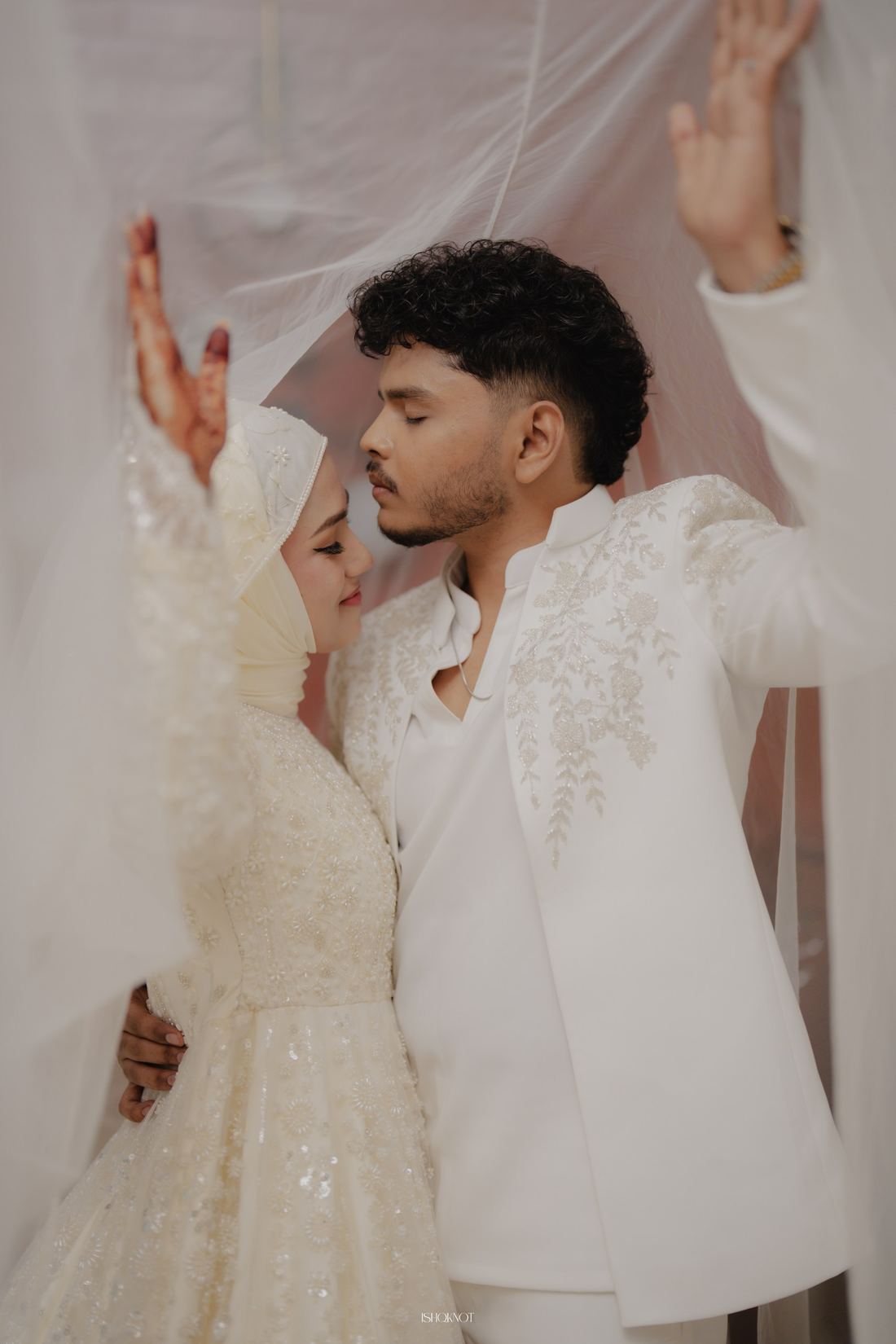 Bride and groom under the bride's veil